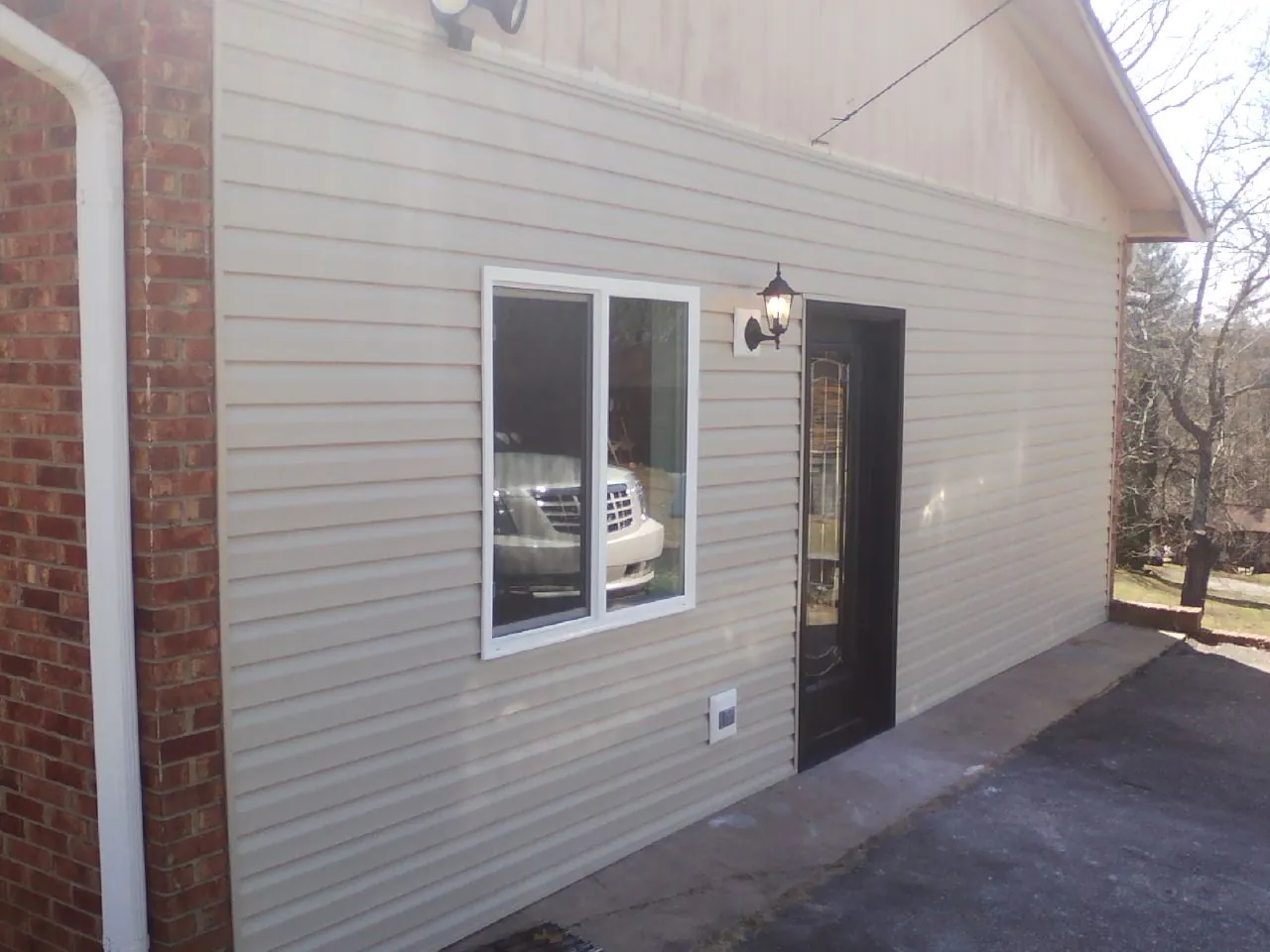 New vinyl siding and entry door on a room addition in Munday