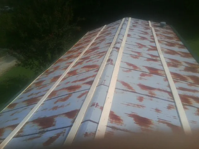 Rusted metal roof panels with new wood purlins before replacement — Storm Damage Roof Repair in Munday by Roofing Brothers