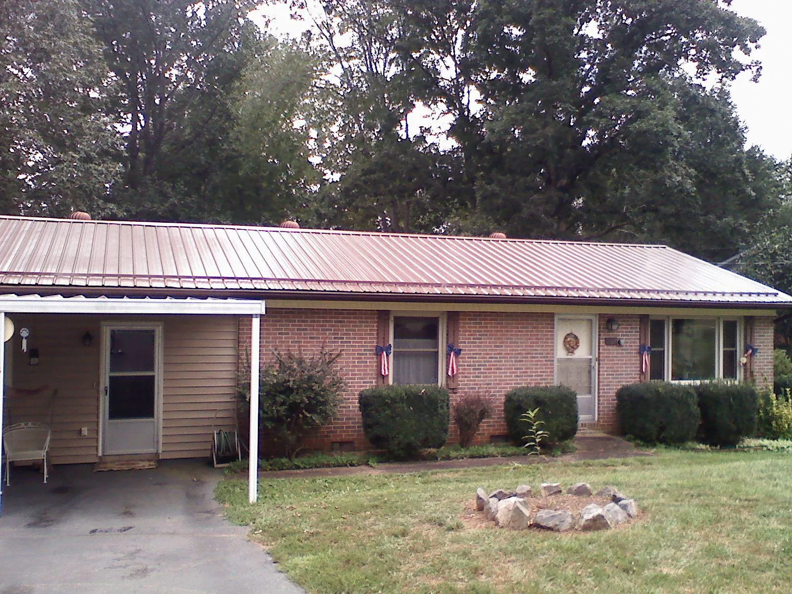 Bronze metal roof and carport on a brick ranch home — Roof Repair work by our crew in Munday