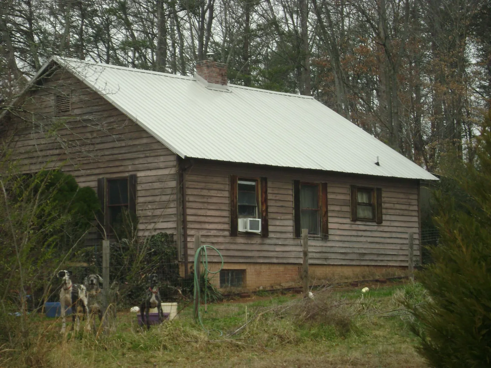 White metal roof on an old wood sided farmhouse, from a Metal Roof Installation job in Munday